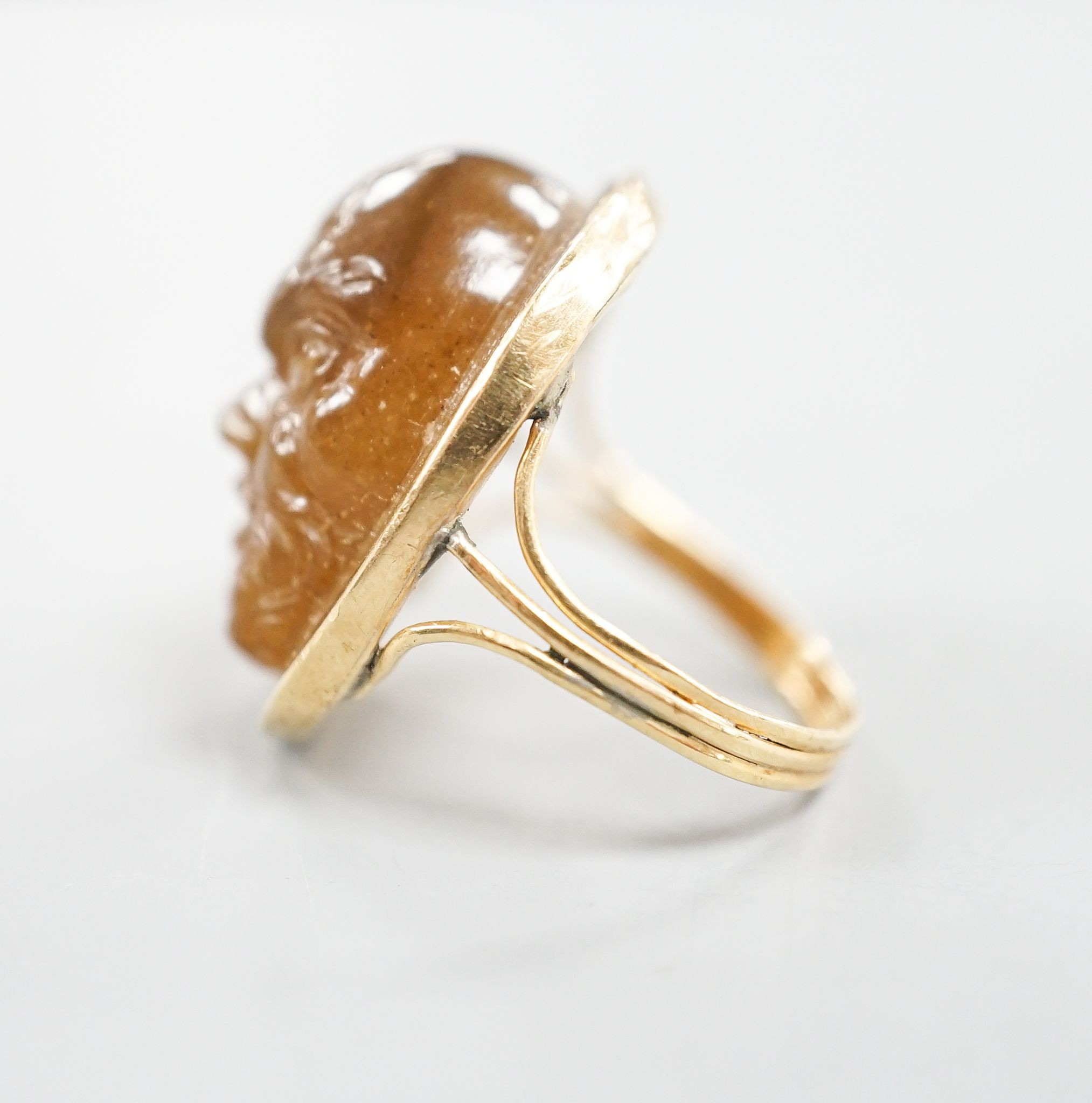 A yellow metal and cabochon brown chalcedony, carved with the face of a gentleman, size K, gross weight 7.3 grams.